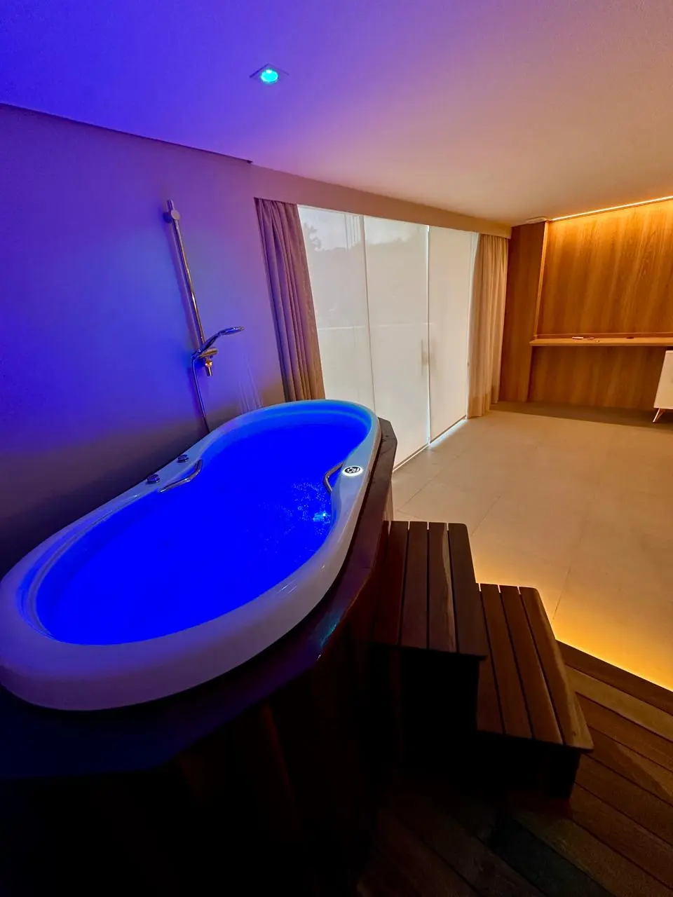 Blue-lit hydromassage soaking tub at Drs da Beleza