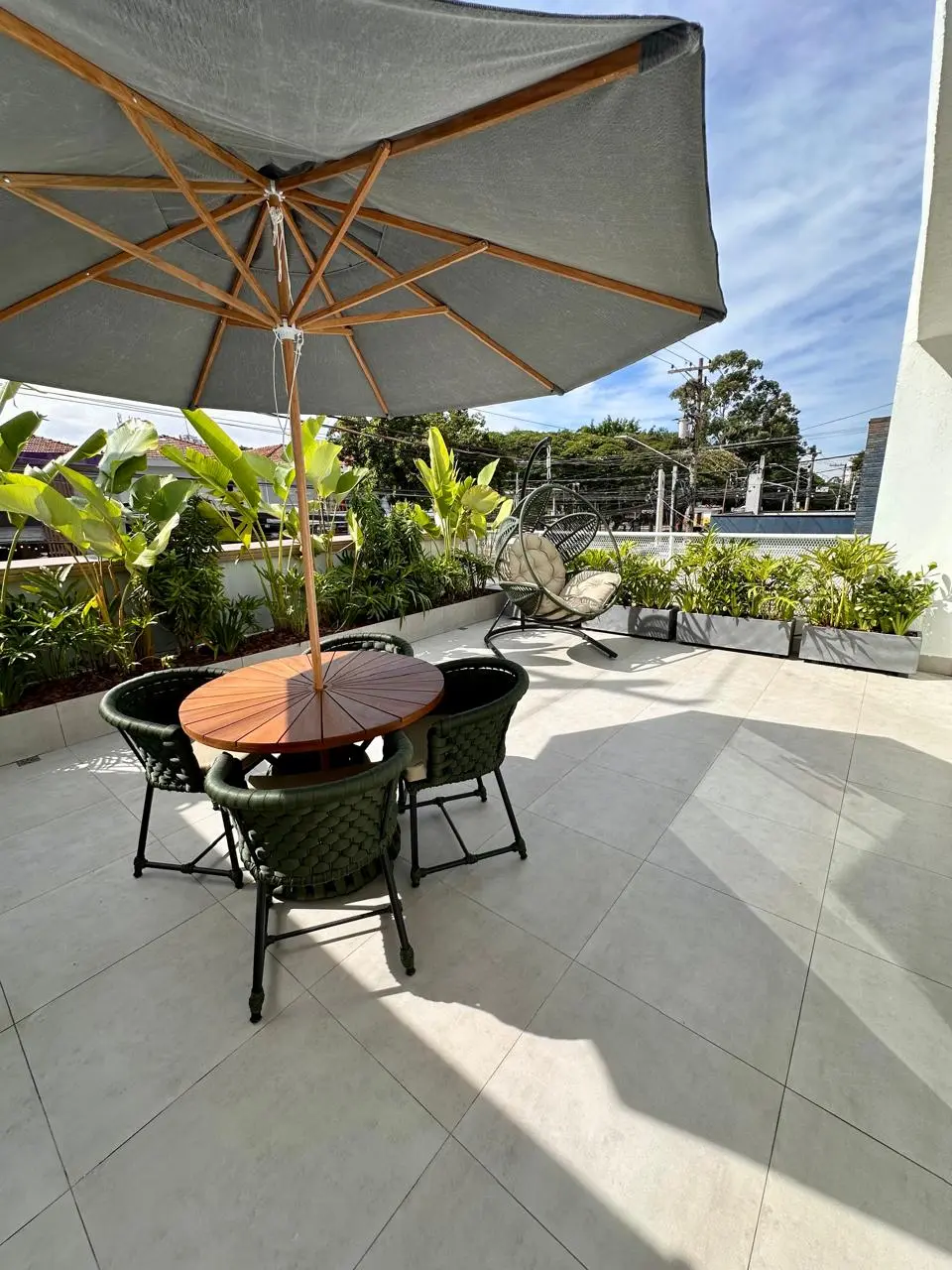 Outdoor lounge area with an umbrella at Drs da Beleza